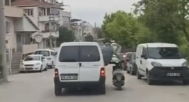 Motosikleti seyir halindeki aracın camından sarkarak götürdü